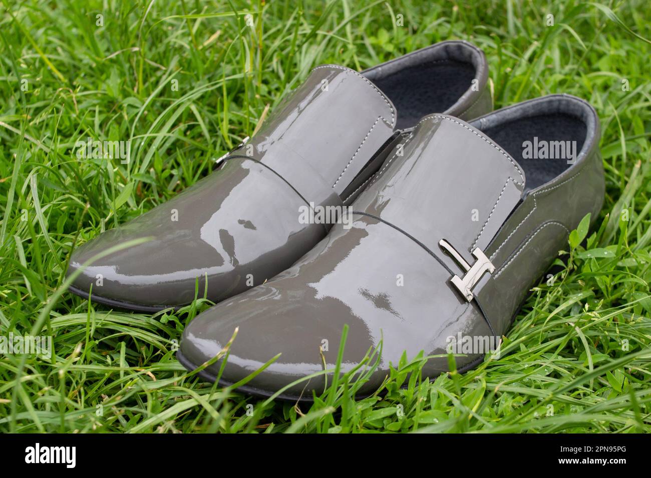 chaussures modernes grises pour hommes sur l'herbe au printemps Banque D'Images