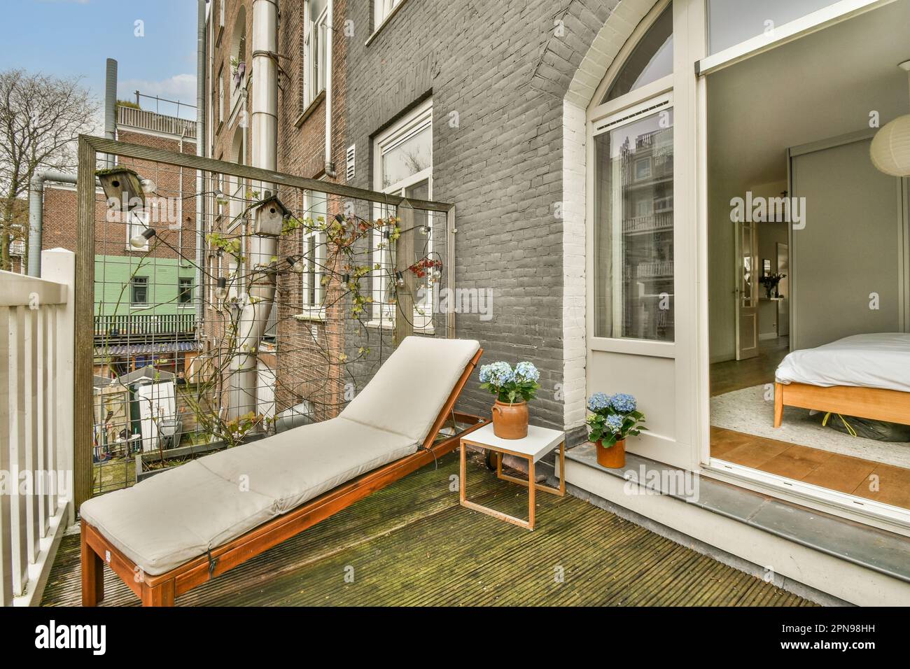 une zone extérieure avec un lit, une chaise et une fenêtre dans la photo  est prise d'une autre pièce de l'autre côté Photo Stock - Alamy