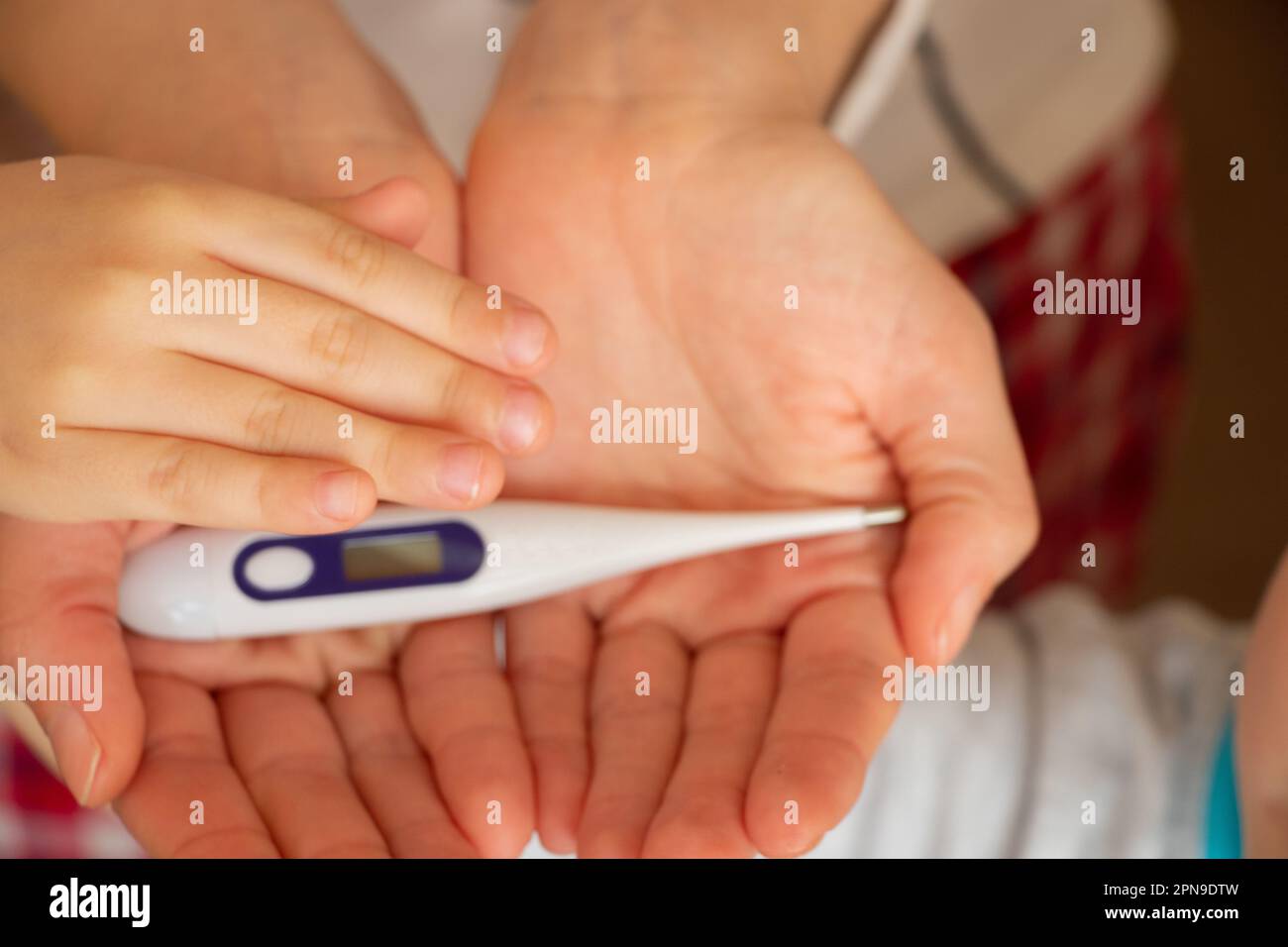 les mains des femmes tiennent un thermomètre électronique Banque D'Images