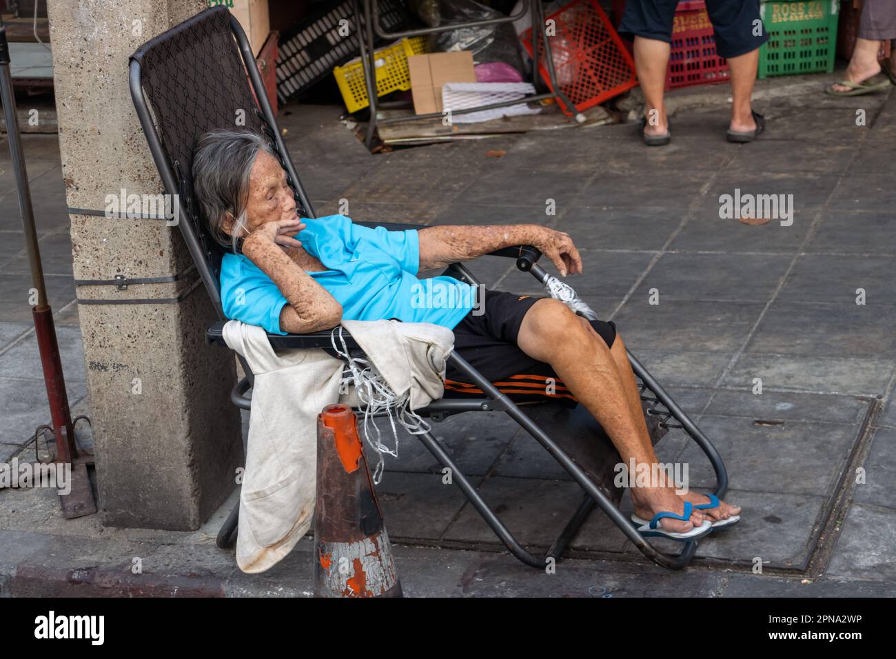 BANGKOK, THAÏLANDE, FÉVRIER 04 2023, au carrefour de la ville, une vieille  femme s'assoit sur un transat et observe les environs Photo Stock - Alamy