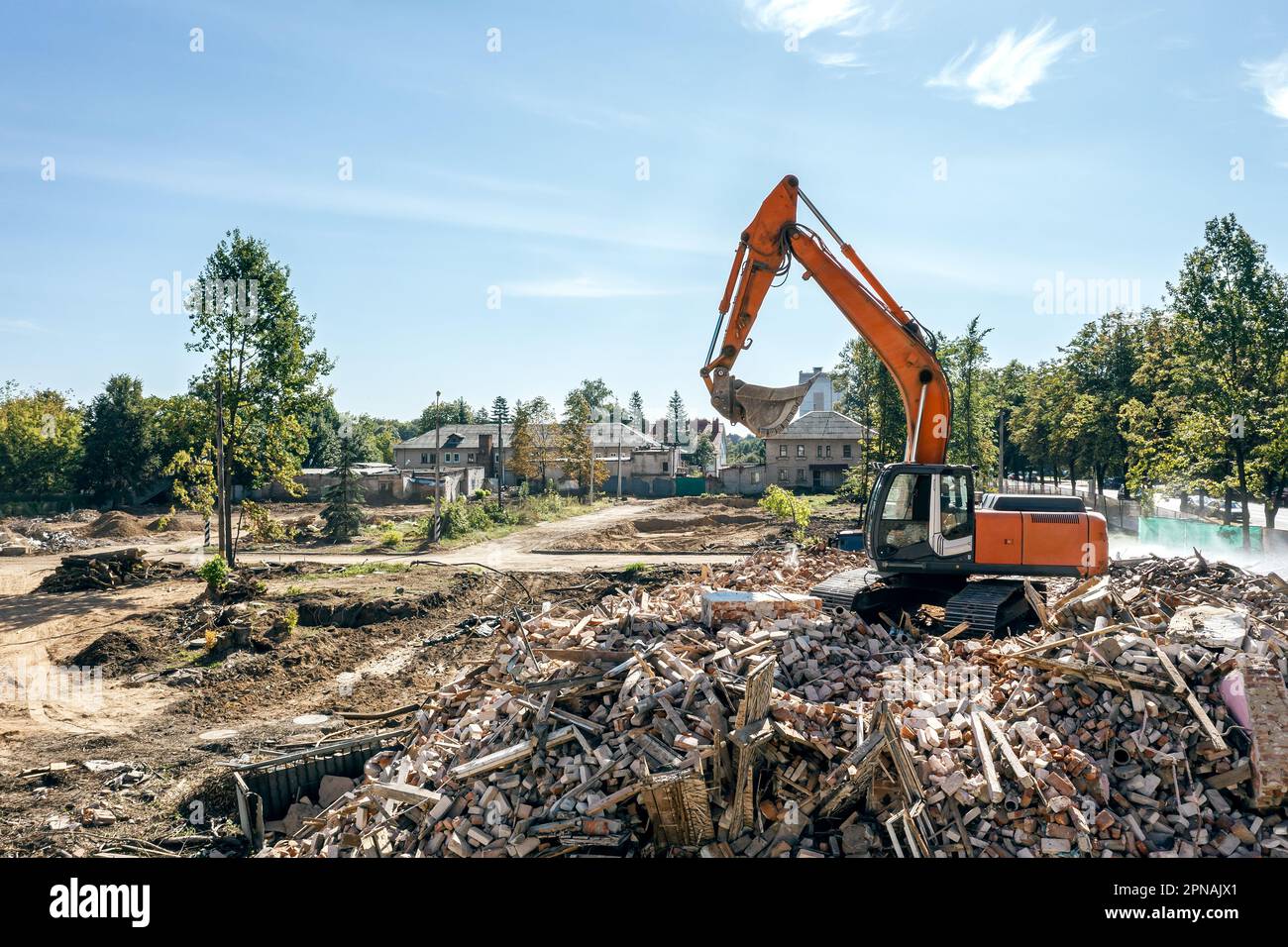 pelle hydraulique sur un tas de débris d'un bâtiment démonté sur un site de démolition. photo de drone. Banque D'Images