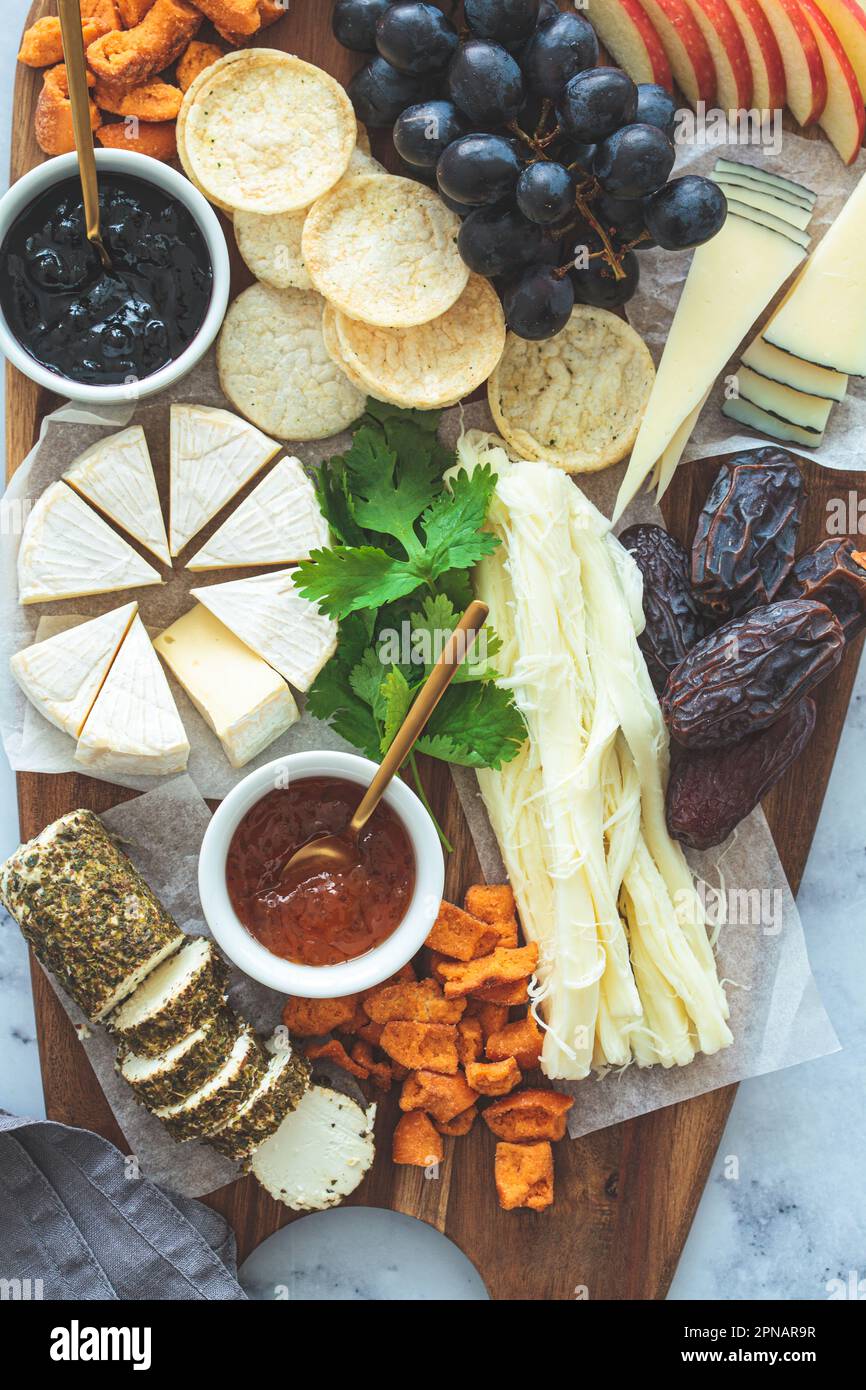 Plateau de fromages avec fruits et craquelins, gros plan. Plats de fête, plat, hors-d'œuvre européens. Banque D'Images