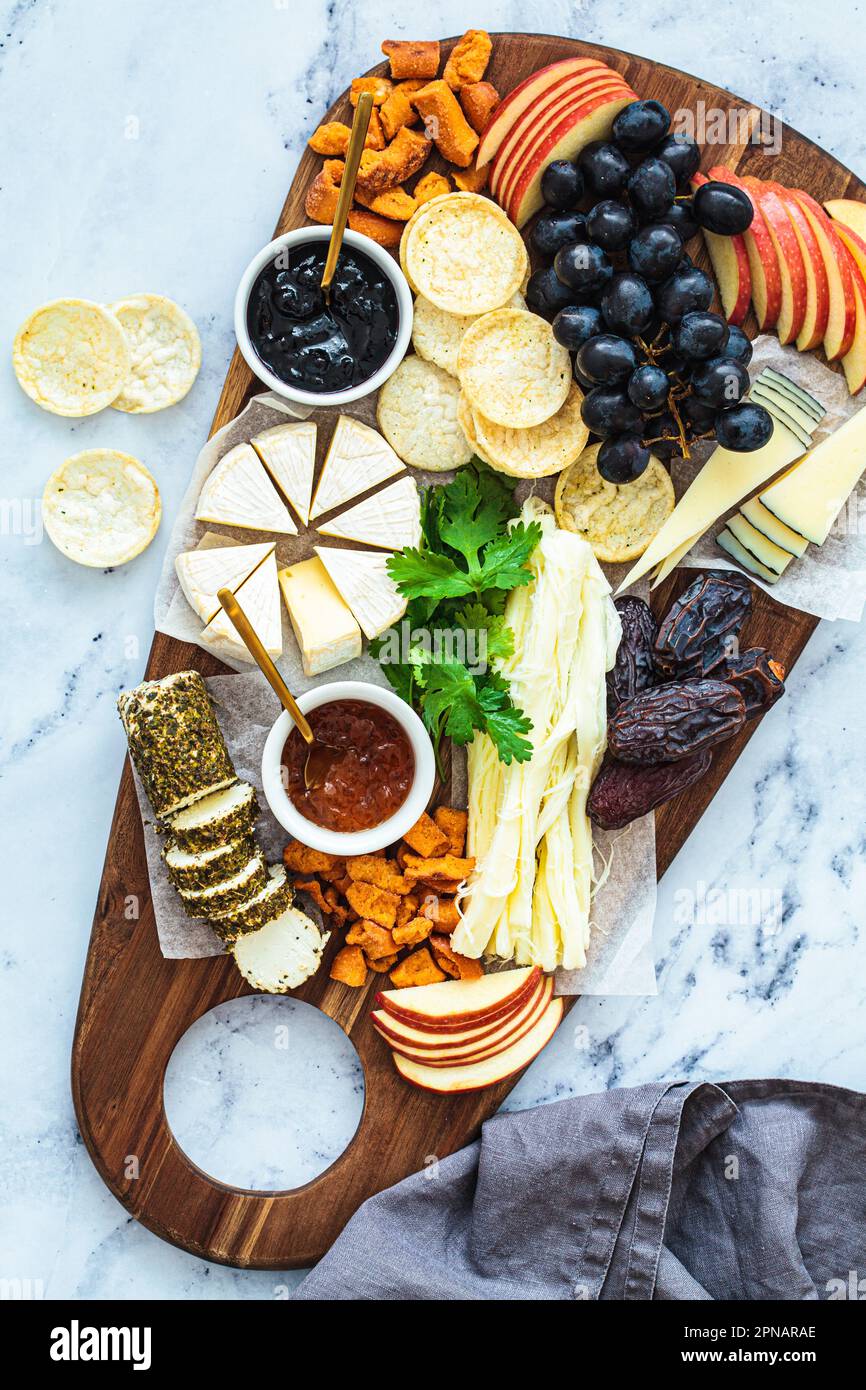 Plateau de fromages avec fruits et craquelins, vue du dessus. Plats de fête, plat, hors-d'œuvre européens. Banque D'Images