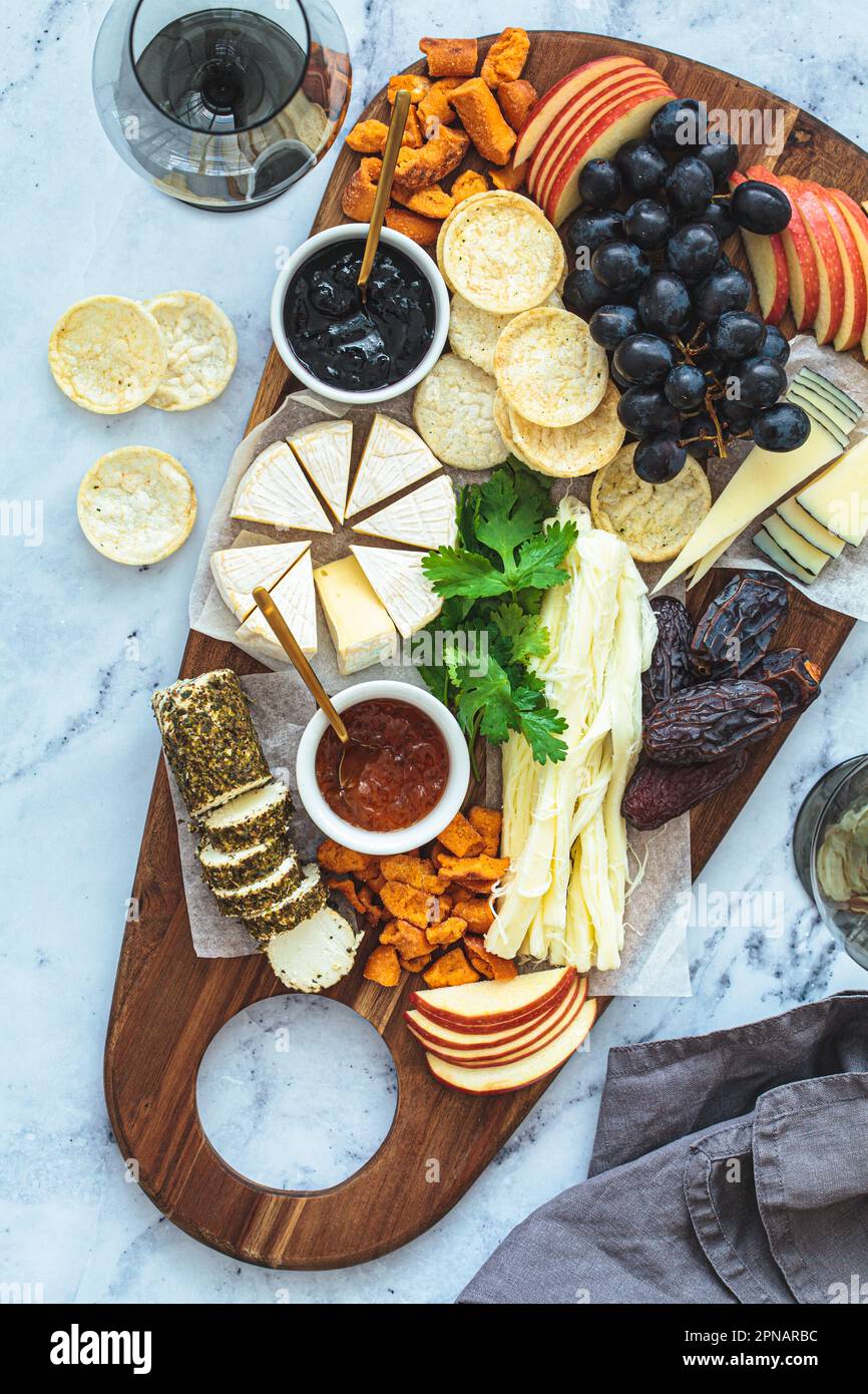 Plateau de fromages avec fruits et craquelins, vue du dessus. Plats de fête, plat, hors-d'œuvre européens. Banque D'Images