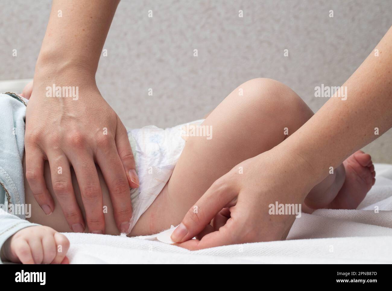 La mère attache les attaches et change la couche du bébé, gros plan Photo  Stock - Alamy