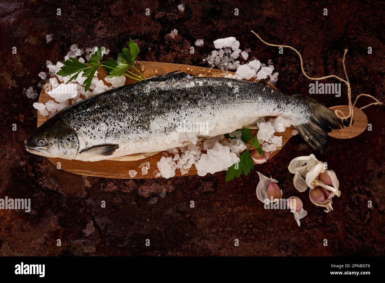 Vue de dessus de poissons frais non cuits avec de la glace et des feuilles vertes sur la surface rocheuse Banque D'Images