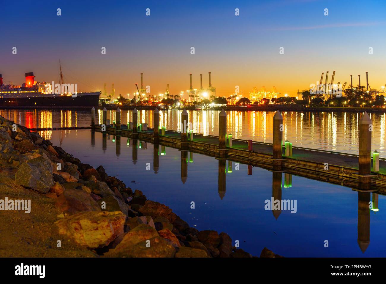 Couleurs vives et lumières éblouissantes de long Beach Harbour la nuit, avec la jetée pittoresque et la reine Marie ajoutant à l'ambiance magique de la scène. Banque D'Images
