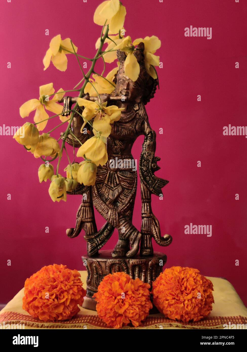 Idole en laiton du Seigneur Krishna décorée de marigold et d'amaltas/fleurs de douche dorées/Vishu/Vishu Kani/Kerala Banque D'Images