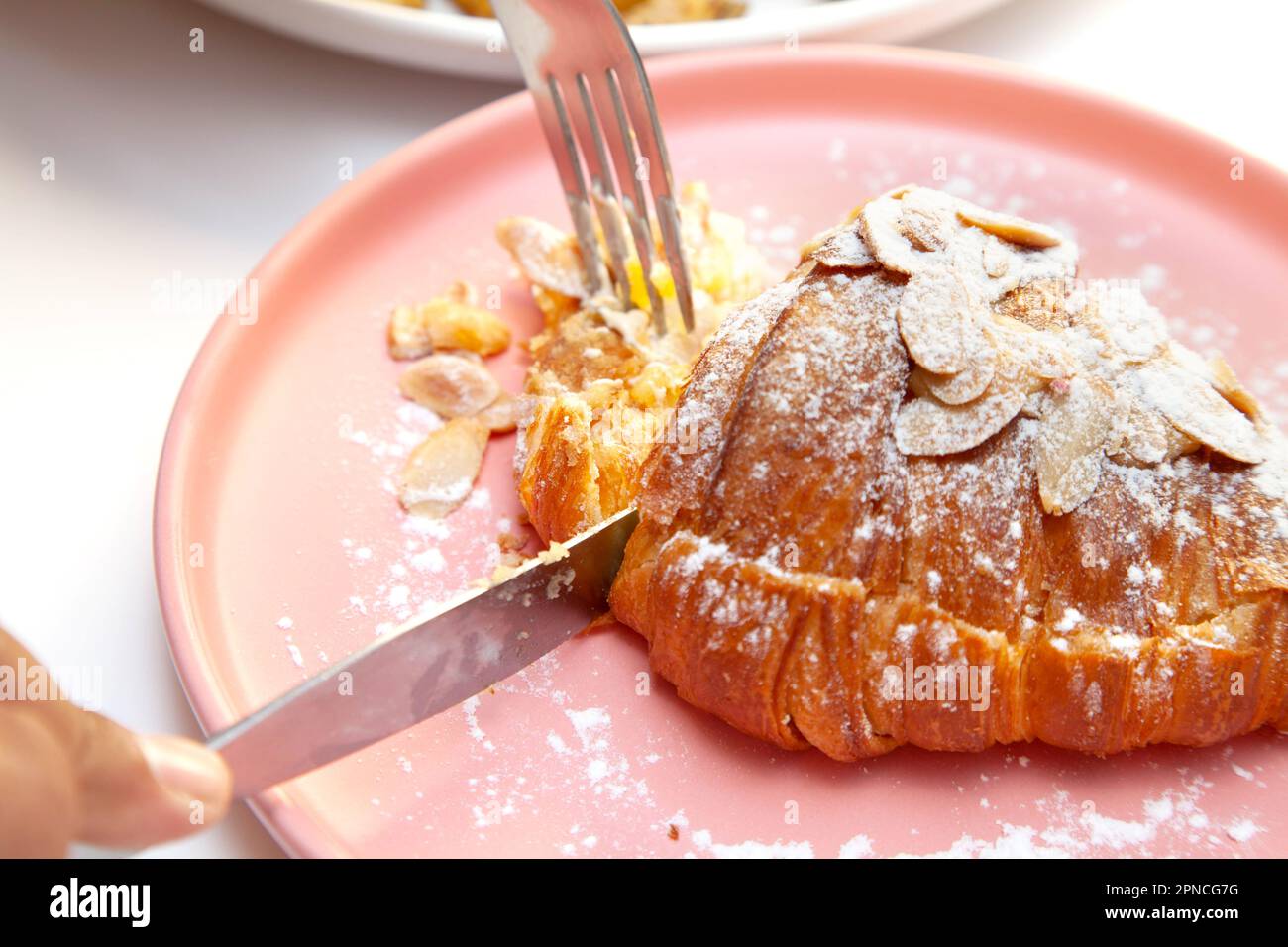 Croissant aux amandes de brioche dans un café chic. Banque D'Images