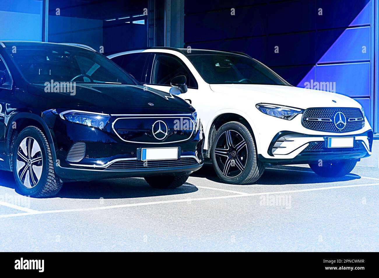 Mercedes-Benz EQA 250 noir batterie SUV électrique année 2023 et nouveau blanc Mercedes-Benz 4MATIC SUV en lumière bleue. Salo, Finlande. 10 avril 2023. Banque D'Images