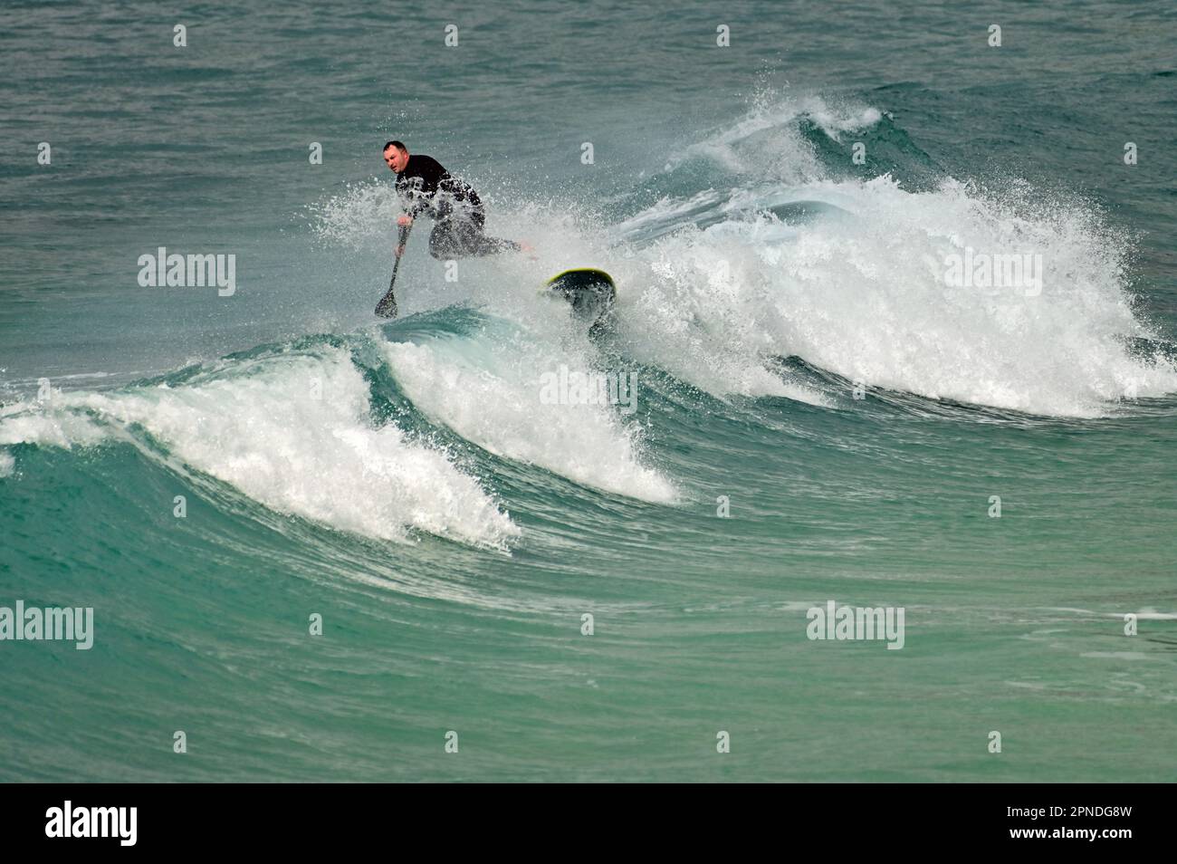 Cornwall, Royaume-Uni. 18th avril 2023. Au cours d'une après-midi chaude et venteuse à Sennen Cove, la maison de surf d'un surfeur Lone prend un Tumble. Crédit photo : Robert Timoney/Alay Live News Banque D'Images
