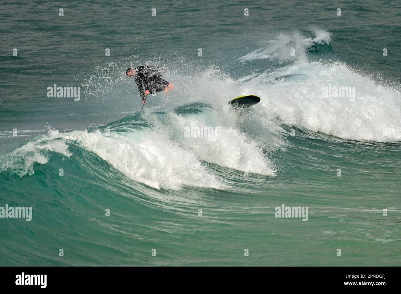 Cornwall, Royaume-Uni. 18th avril 2023. Au cours d'une après-midi chaude et venteuse à Sennen Cove, la maison de surf d'un surfeur Lone prend un Tumble. Crédit photo : Robert Timoney/Alay Live News Banque D'Images