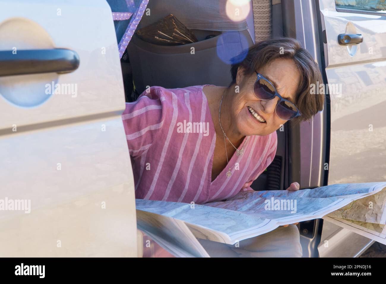 femme âgée sur une carte de triche de camionnette de camping avec des lunettes de soleil Banque D'Images