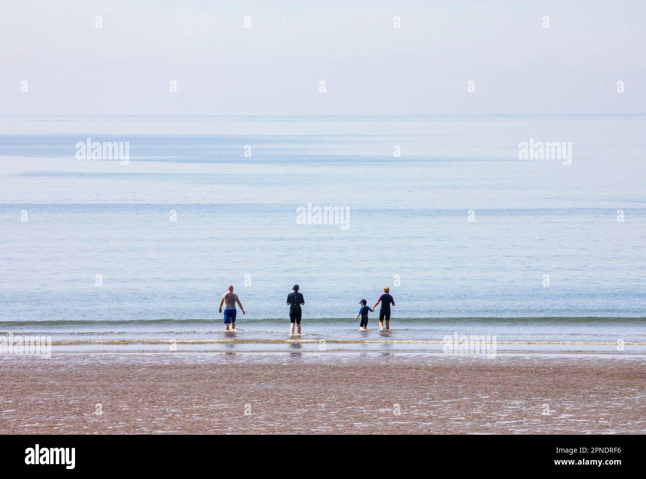 baigneurs entrant dans la mer calme Banque D'Images