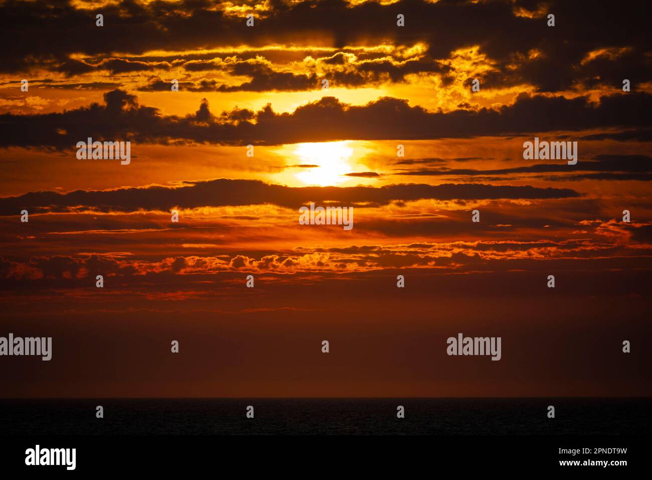 Coucher du soleil d'un navire en mer au milieu des nuages. Banque D'Images
