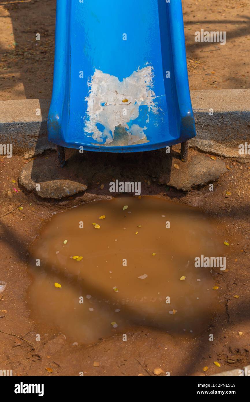 Diapositive bleue menant à une flaque d'eau indiquant des problèmes si elle est utilisée Banque D'Images