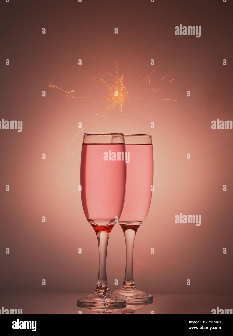 Paire de verres à champagne rose sur fond dégradé rose. Banque D'Images