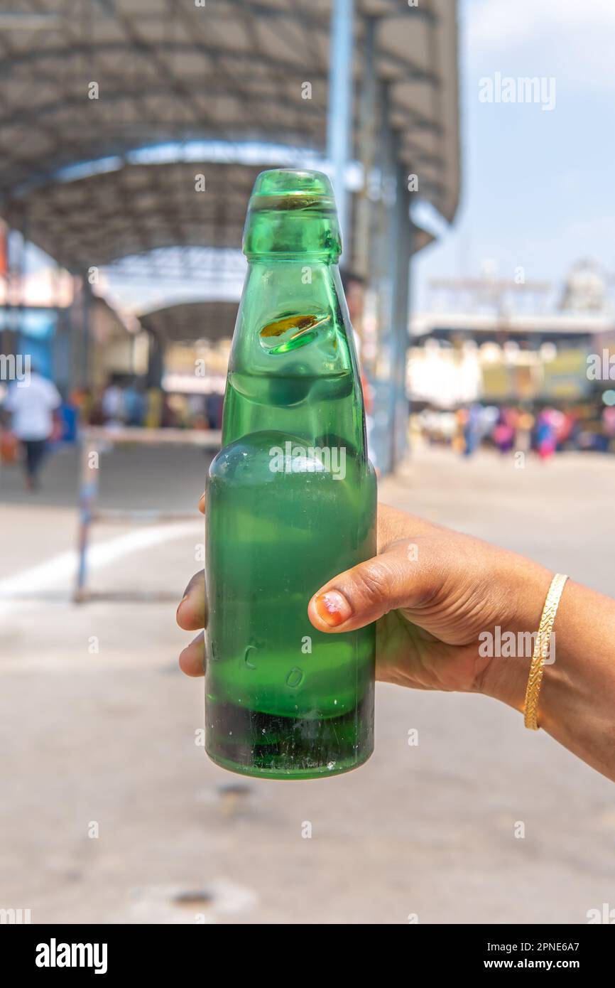 Une jeune femme tenant une bouteille de soda de goli un beau jour. bouteille de soda avec bouchon circulaire en marbre. Une boisson traditionnelle rafraîchissante Banque D'Images