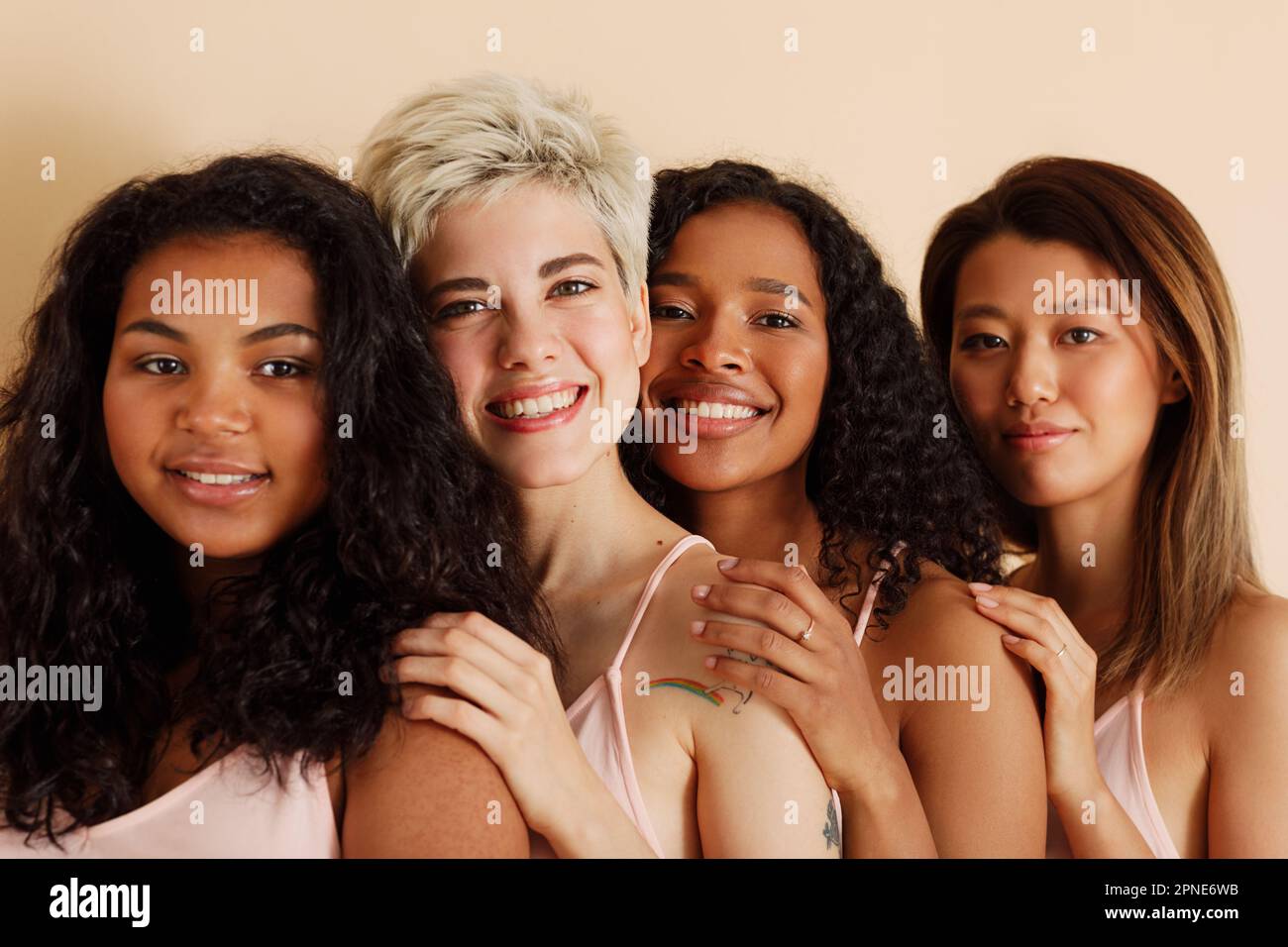 Quatre jeunes femmes avec différentes tons de peau regardant l'appareil photo. Diverses femmes debout ensemble. Banque D'Images