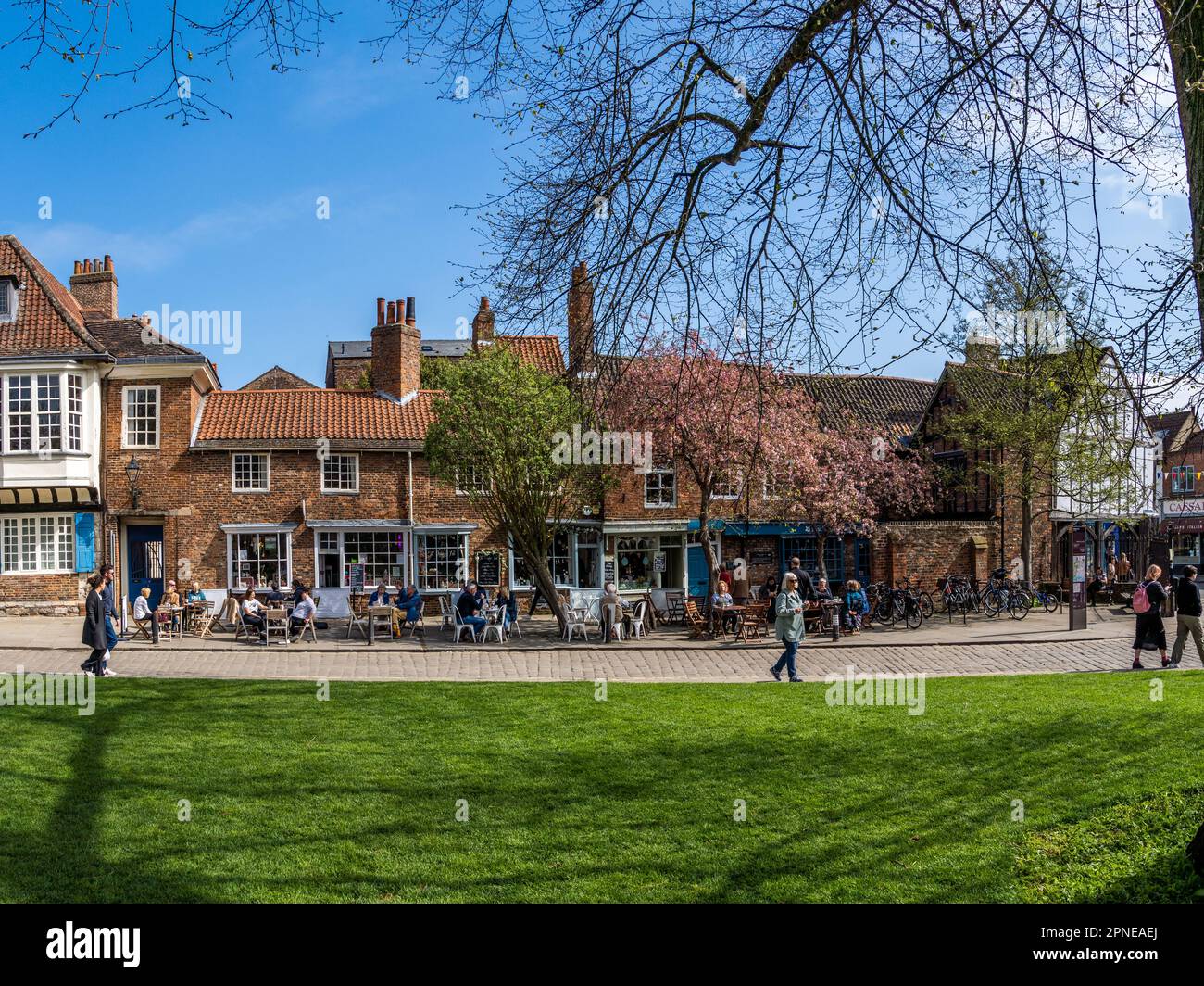 ST WILLIAM'S COLLEGE, YORK, ROYAUME-UNI - 17 AVRIL 2023. Touristes et locaux assis aux tables extérieures des cafés locaux dans le centre de York sur une somme ensoleillée Banque D'Images