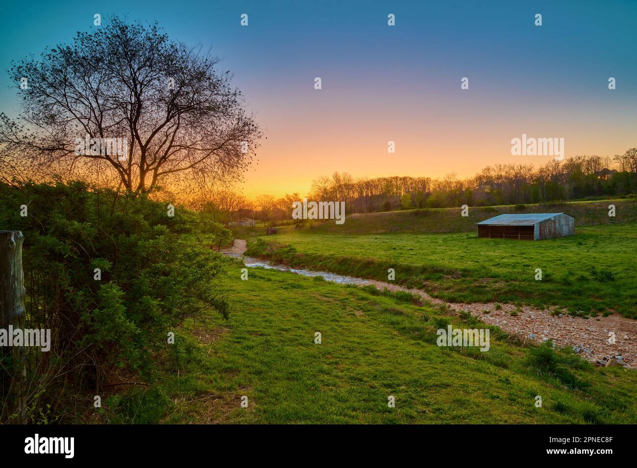 Coucher de soleil sur une ferme avec ancienne grange près de Bentonville Arkansas. Banque D'Images