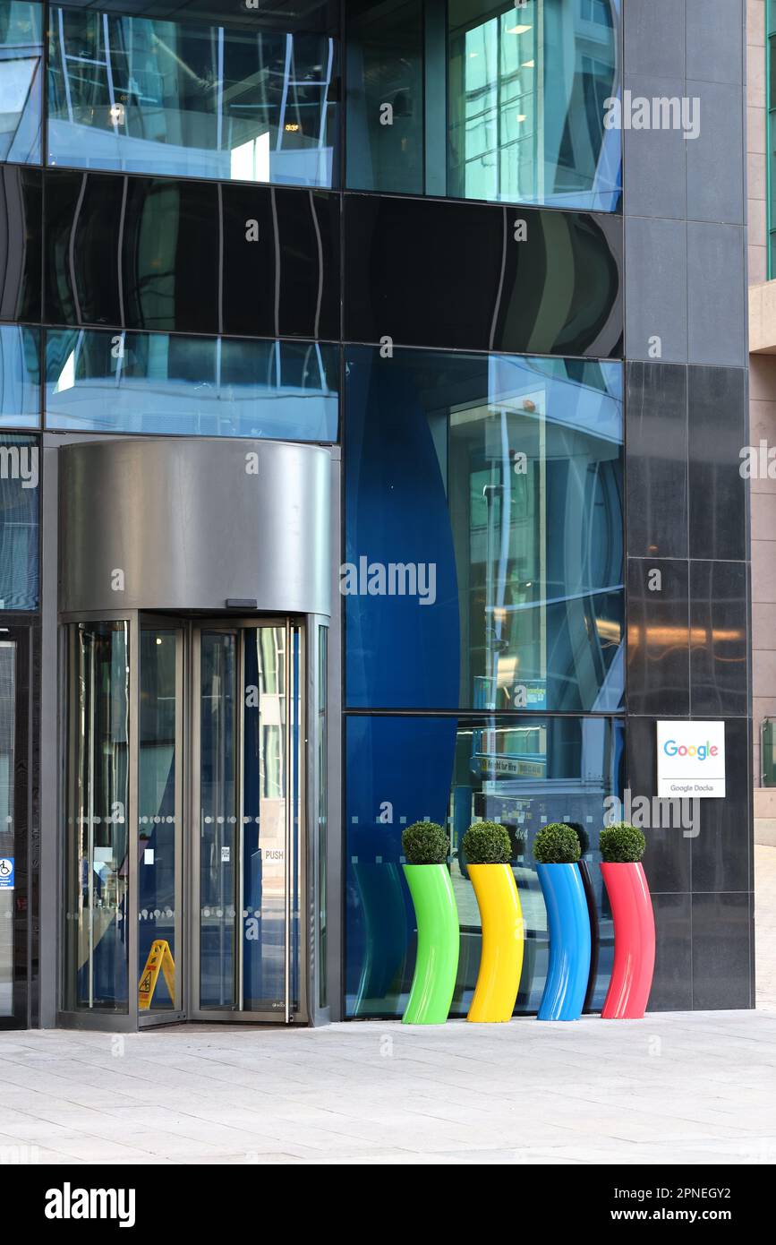 Bureaux de la société Google ou bâtiment de bureau. Extérieur de l'entreprise technologique avec porte d'entrée de sortie pivotante et logo de marque coloré. Dublin, Irlande Banque D'Images