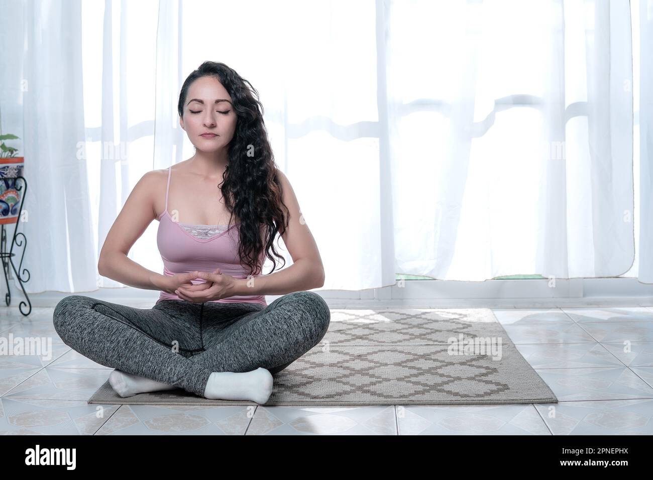 mature belle femme faisant des pilates de yoga et des exercices d'étirement dans le confort de sa maison heureuse et calme Banque D'Images