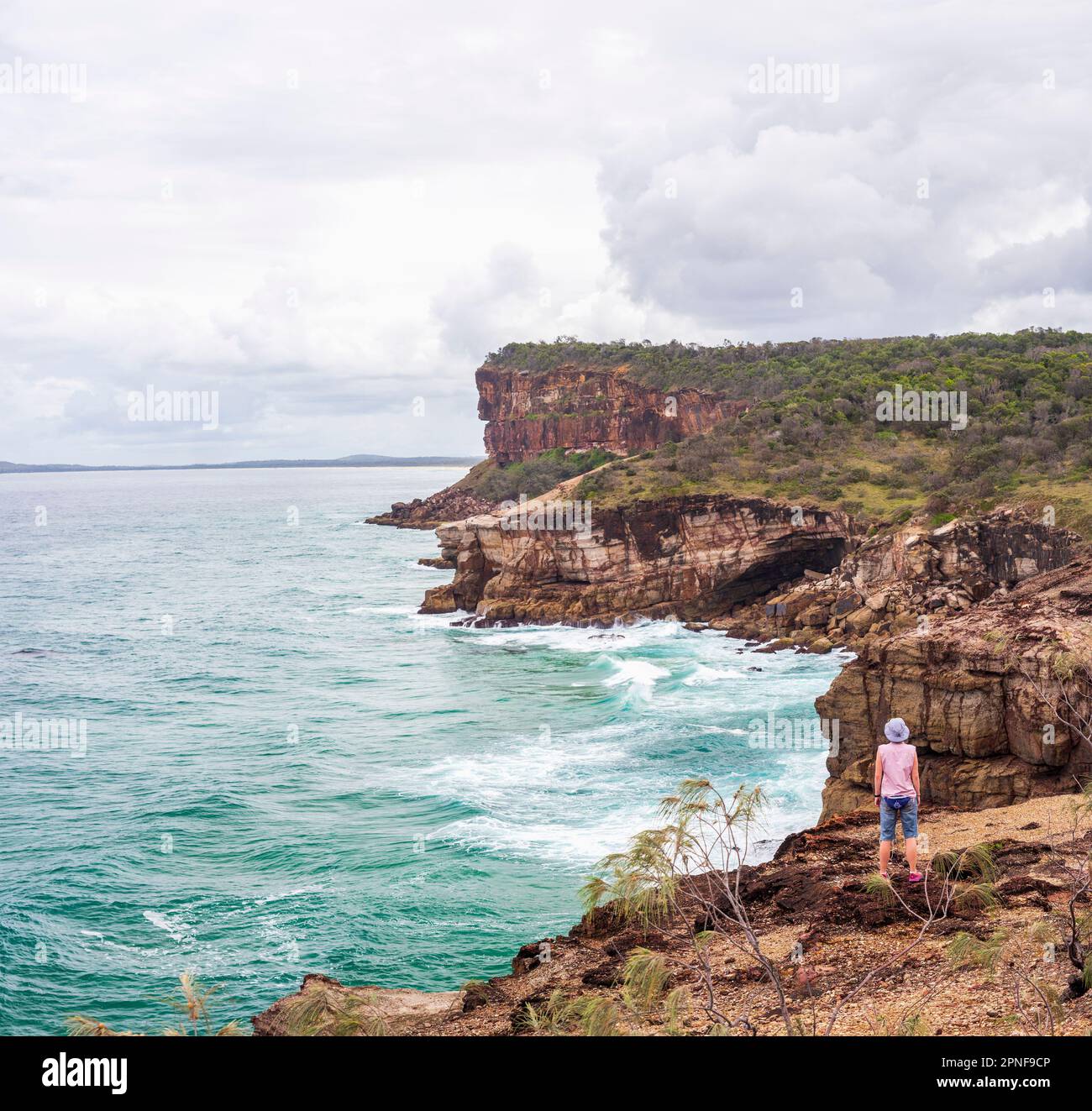 Australie, Nouvelle-Galles du Sud, Port Macquarie, femme debout sur la falaise et regardant la vue Banque D'Images