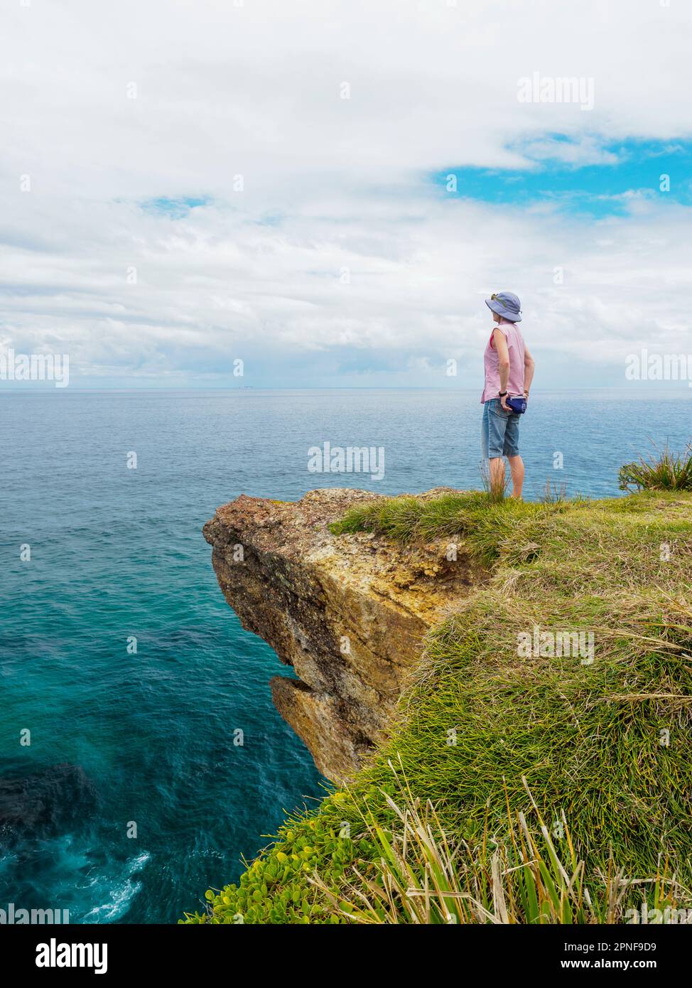 Australie, Nouvelle-Galles du Sud, Port Macquarie, femme debout sur la falaise et regardant la vue Banque D'Images