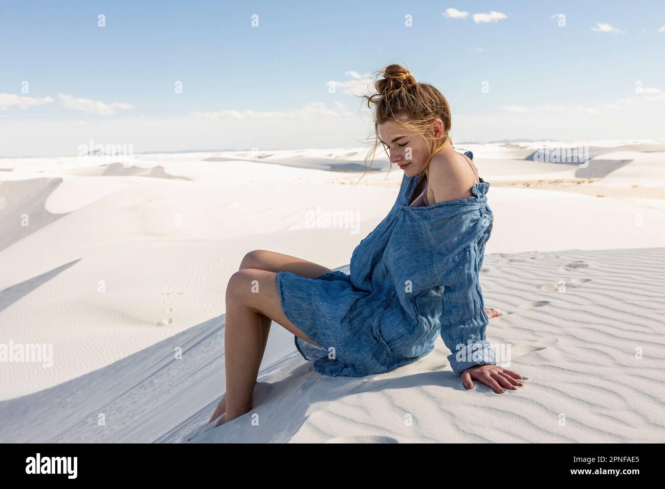 États-Unis, Nouveau-Mexique, parc national de White Sands, jeune fille assise sur le sable Banque D'Images