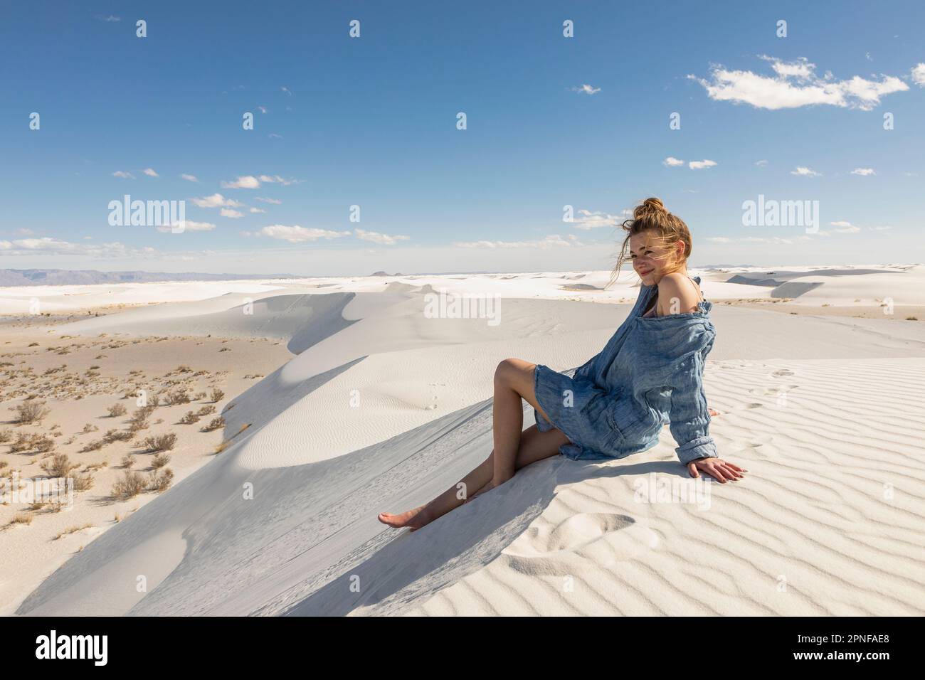 États-Unis, Nouveau-Mexique, parc national de White Sands, jeune fille assise sur le sable Banque D'Images