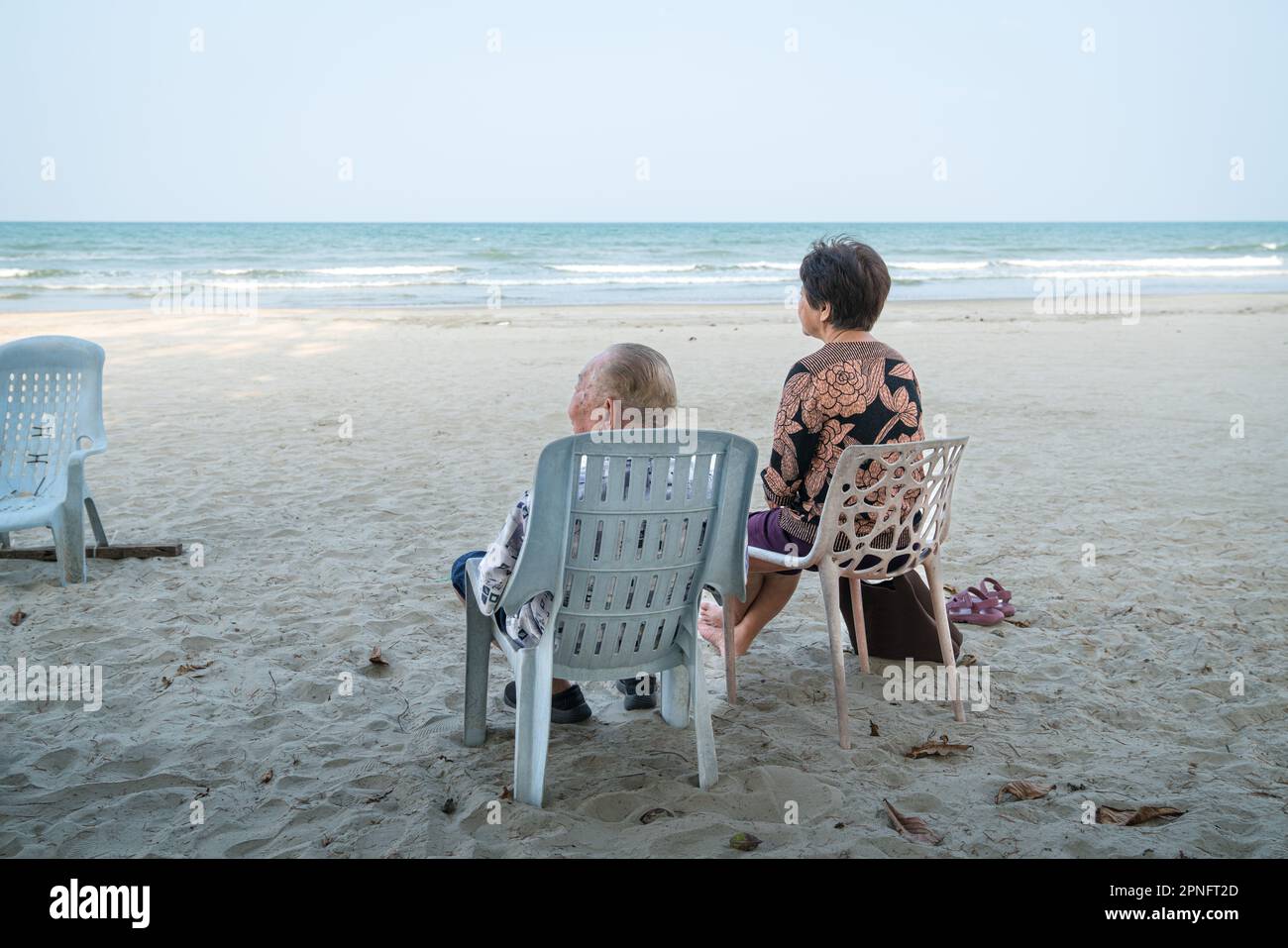 Couple senior se détendant sur la plage, regardant la mer. Concept de vacances pour les personnes âgées et les retraités. Banque D'Images