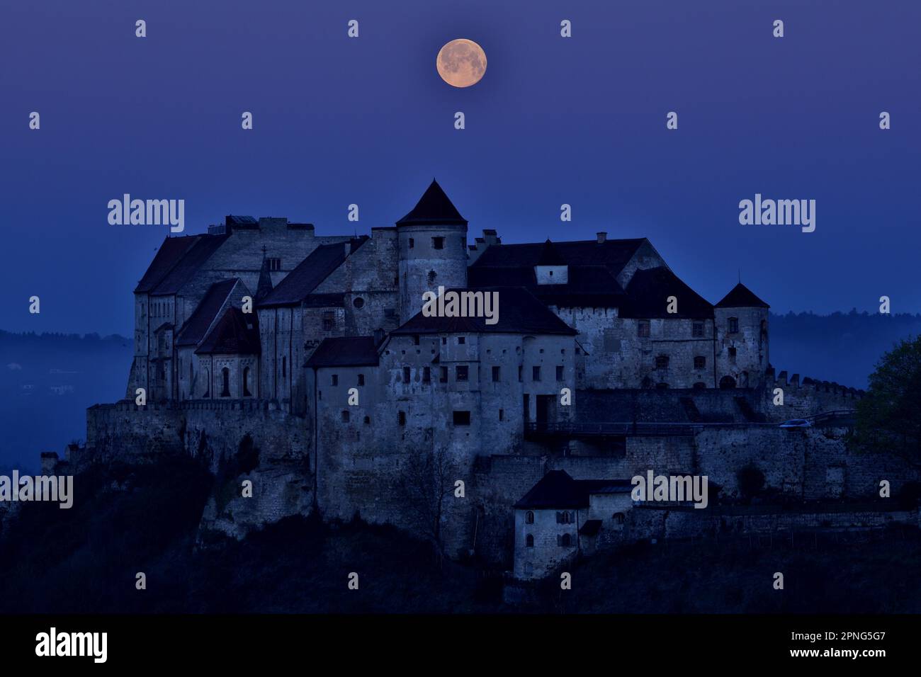 La pleine lune se dresse derrière le château de Burghausen, lumière bleue du matin, Burghausen, haute-Bavière, Bavière, Allemagne Banque D'Images
