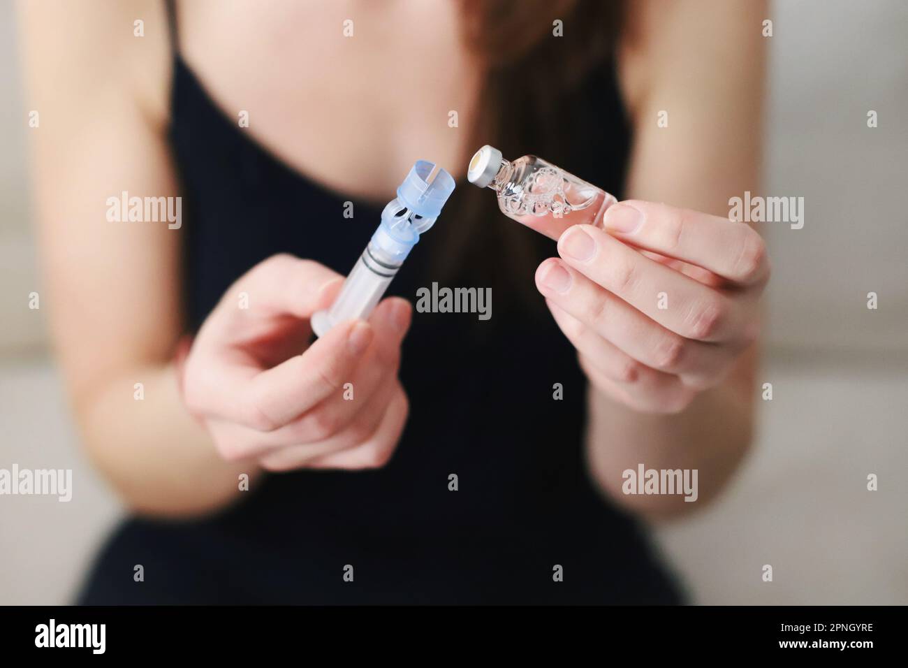 Femme remplissant le réservoir de sa pompe à insuline avec de l'insuline Banque D'Images