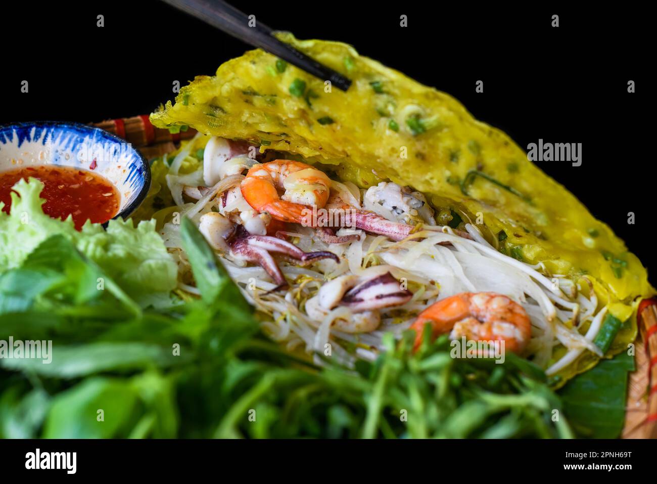 Crêpes vietnamiennes Banh xeo avec fruits de mer sur fond noir vue de dessus Banque D'Images