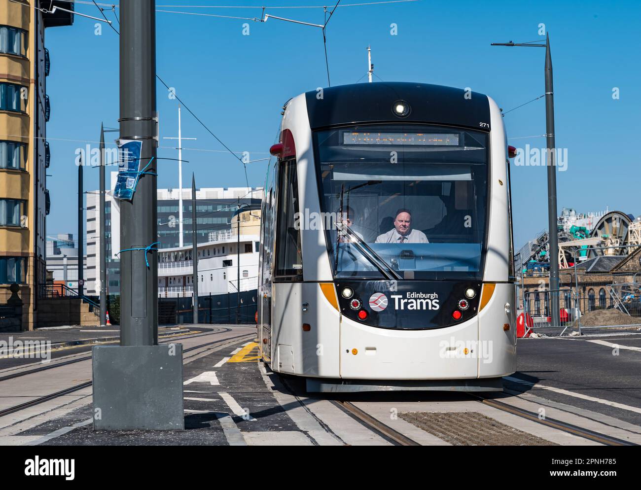 Leith, Édimbourg, Écosse, Royaume-Uni, 19th avril 2023. Trams à destination de Newhaven en cours d'exécution : les premiers trams à emprunter la ligne de tramway étendue pendant la journée ont commencé aujourd'hui pour tester l'itinéraire. Photo : un tramway passe devant 'Fingal Edinburgh', un hôtel flottant de luxe. Crédit : Sally Anderson/Alay Live News Banque D'Images