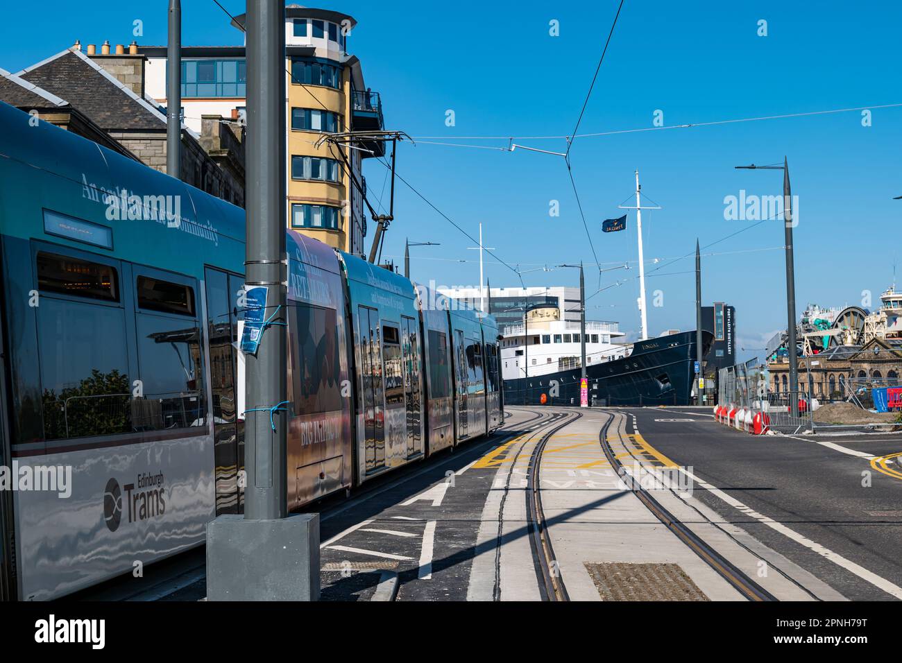 Leith, Édimbourg, Écosse, Royaume-Uni, 19th avril 2023. Trams à destination de Newhaven en cours d'exécution : les premiers trams à emprunter la ligne de tramway étendue pendant la journée ont commencé aujourd'hui pour tester l'itinéraire. Photo : un tramway passe devant 'Fingal Edinburgh', un hôtel flottant de luxe. Crédit : Sally Anderson/Alay Live News Banque D'Images