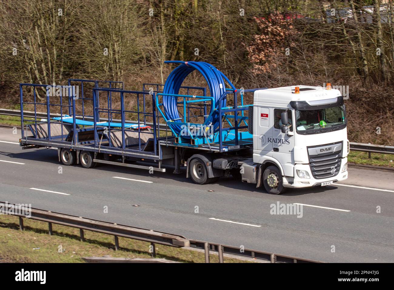 SYSTÈMES RADIUS, composants en polyéthène pour conduites sous pression XPO Logistics DAF XF tractant une remorque à LL20 marches ; se déplaçant sur l'autoroute M6 dans le Grand Manchester, Royaume-Uni Banque D'Images