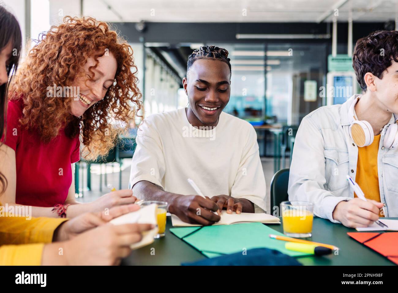 Jeune groupe d'étudiants amis qui font leurs devoirs ou préparent l'examen ensemble Banque D'Images