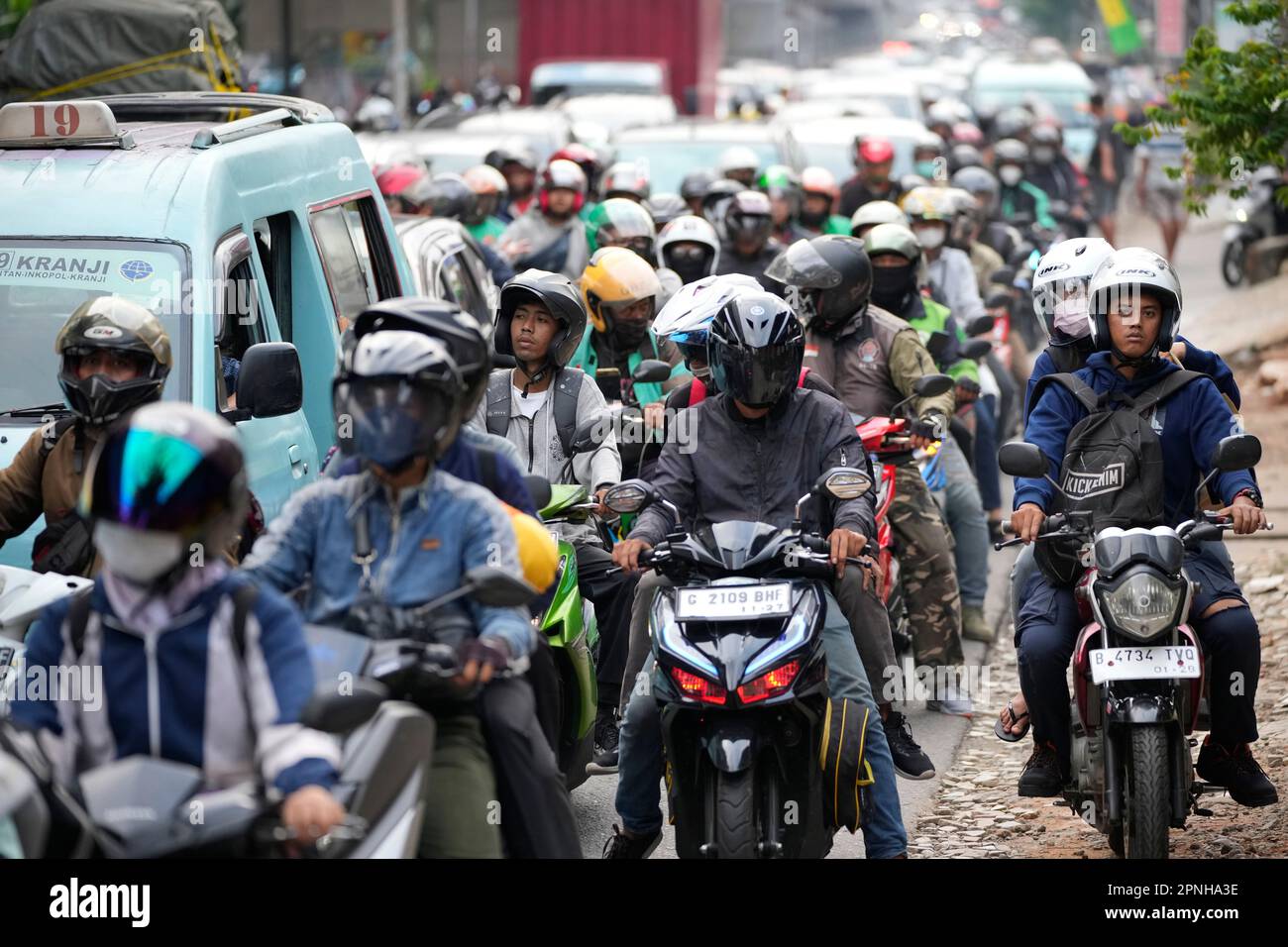 People ride motorcycles to their home village, leaving from Jakarta