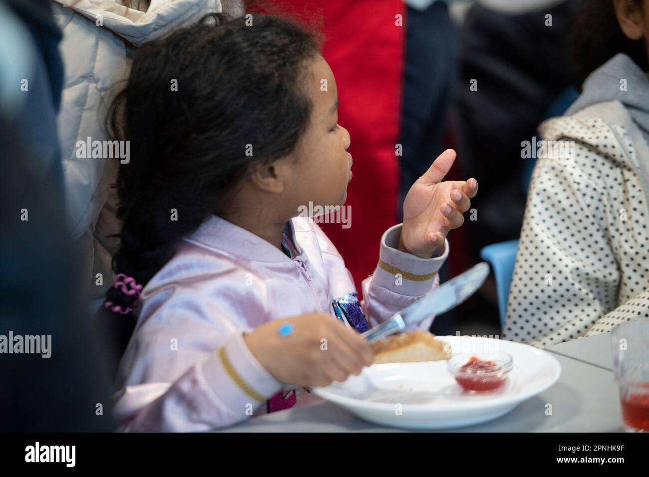Eat, Allemagne. 19th avril 2023. Une écolière distribue du pain avec de la confiture, le projet Brotzeit est destiné à permettre aux enfants de commencer la journée d'école avec le petit déjeuner, l'actrice Uschi GLAS, présidente du projet brotzeit, visite l'école Bischof von Ketteler d'Essen, 19 avril 2023 Credit: dpa/Alamy Live News Banque D'Images
