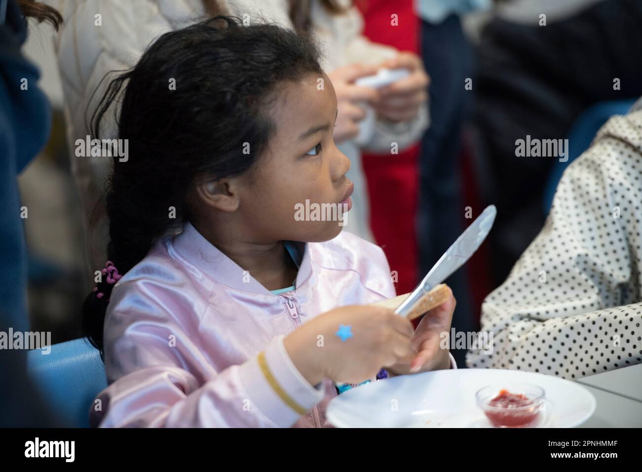Eat, Allemagne. 19th avril 2023. Une écolière distribue du pain avec de la confiture, le projet Brotzeit est destiné à permettre aux enfants de commencer la journée d'école avec le petit déjeuner, l'actrice Uschi GLAS, présidente du projet brotzeit, visite l'école Bischof von Ketteler d'Essen, 19 avril 2023 Credit: dpa/Alamy Live News Banque D'Images
