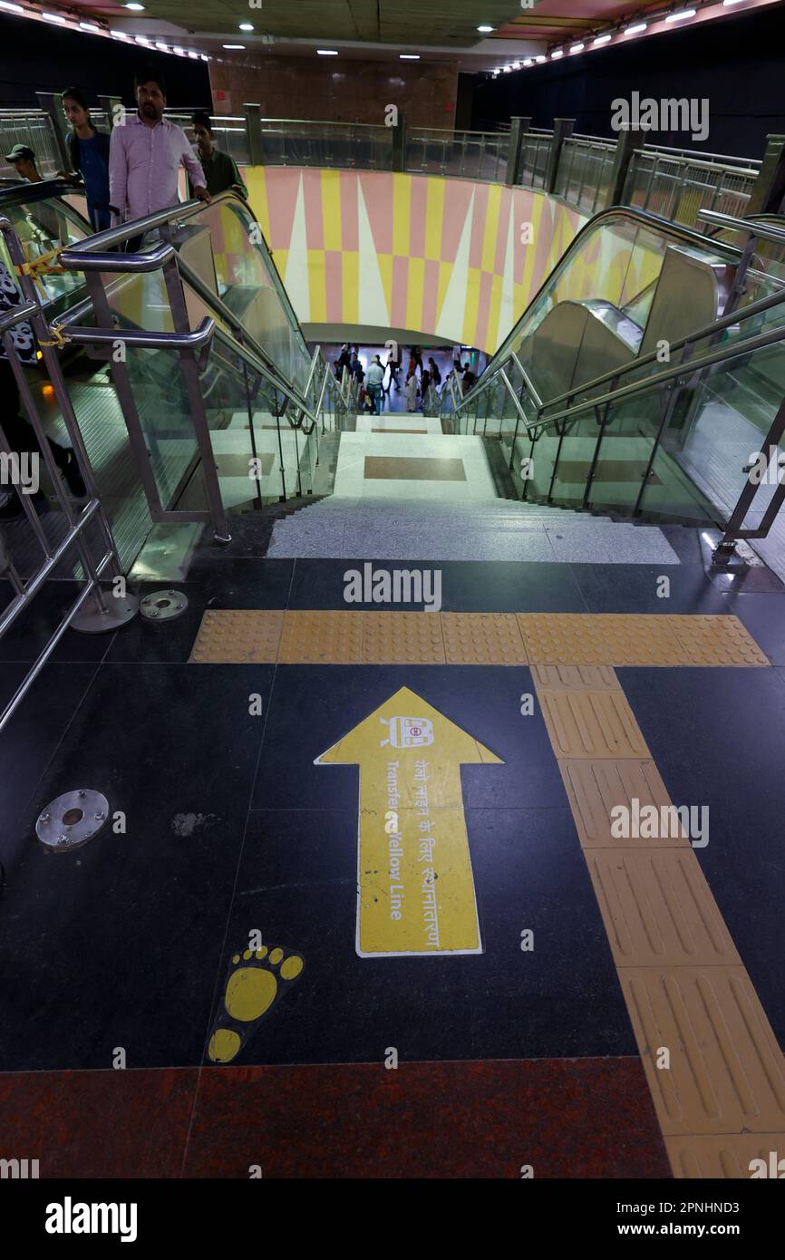 Ligne jaune direction panneau sur le sol dans la station de métro Dilli Haat - INA à Delhi, Inde Banque D'Images