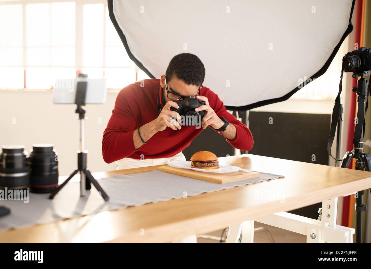 Célèbre photographe en streaming tout en travaillant sur la photographie de nourriture Banque D'Images