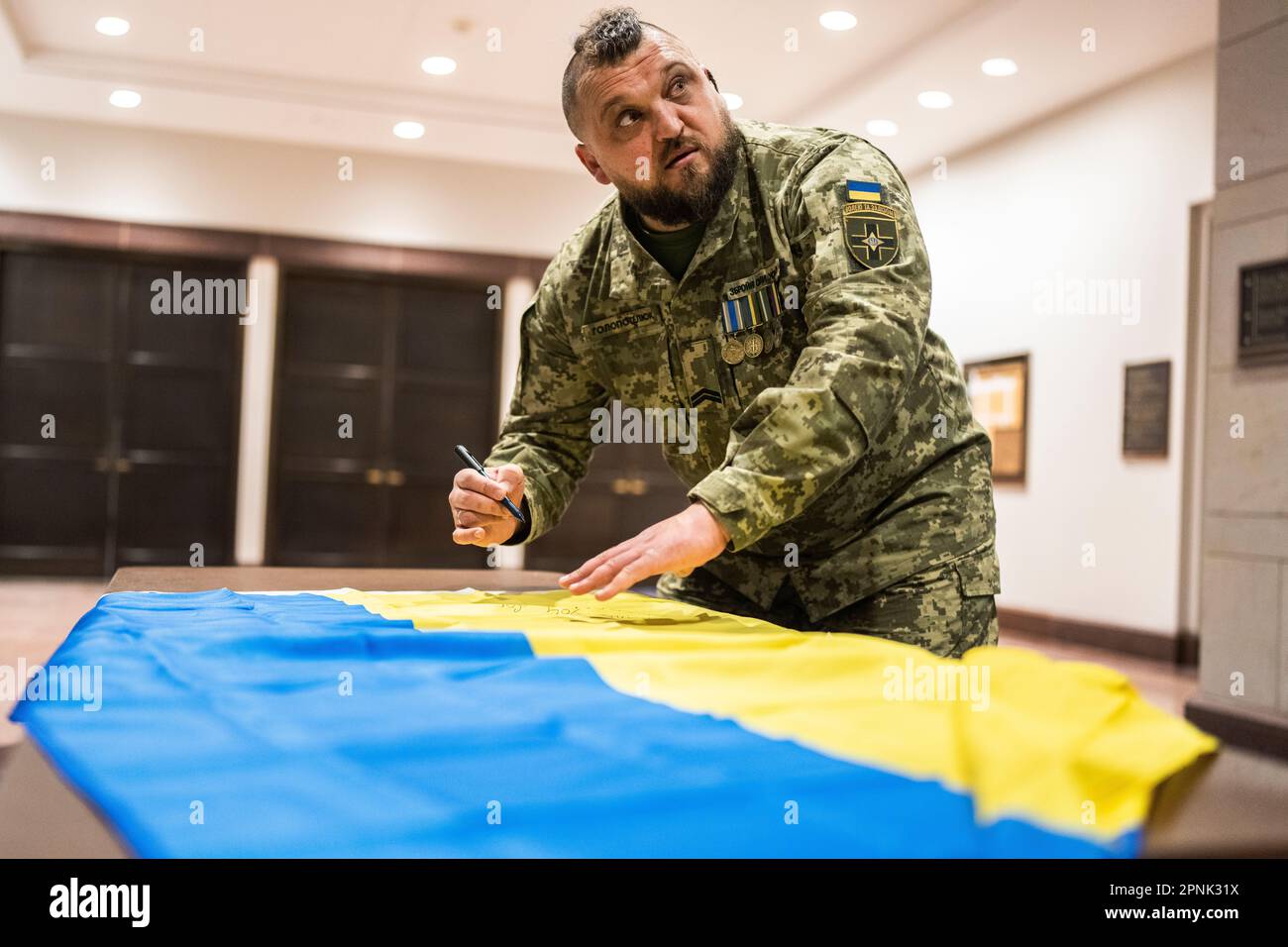 Washington, États-Unis. 19th avril 2023. ÉTATS-UNIS - 19 AVRIL : un soldat ukrainien signe le drapeau de son pays pour le représentant Ted Lieu, D-Californie, devant l'audience de la commission des affaires étrangères de la Chambre des représentants intitulée « Exhibing Putin's crimes: Preuves of Russian War crimes and other Abroes in Ukraine », au Capitol Visitor Center, mercredi, 19 avril 2023. (Tom Williams/CQ Roll Call/Sipa USA) Credit: SIPA US/Alay Live News Banque D'Images