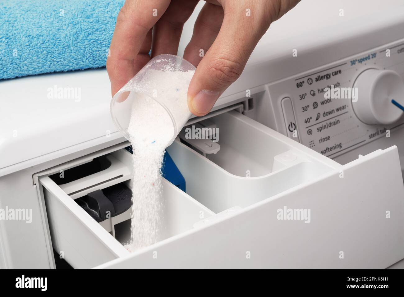 Mettre la lessive en poudre dans le lave-linge. Le concept de blanchisserie. Banque D'Images