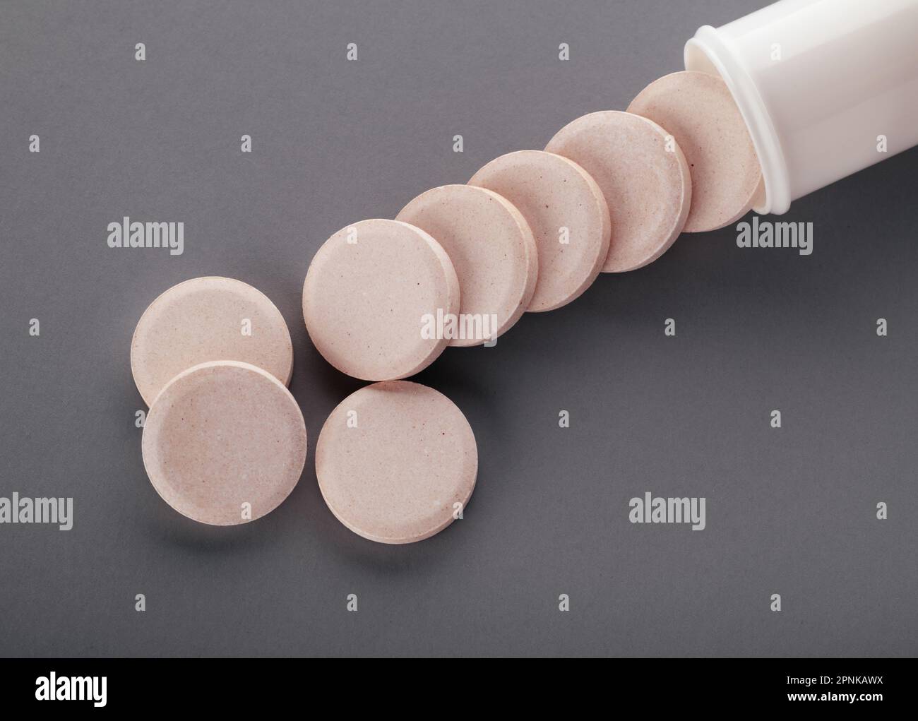 Tube rond blanc mat en aluminium avec bouchon pour comprimés effervescents ou de carbone, pilules, vitamines. Vue latérale. Du nouveau tube a versé des médicaments isolés. Banque D'Images