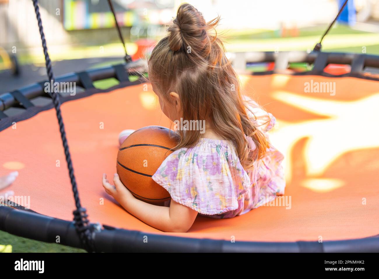 Enfant d'âge préscolaire jouant dans une cour de jardin d'enfants en plein air animée Banque D'Images