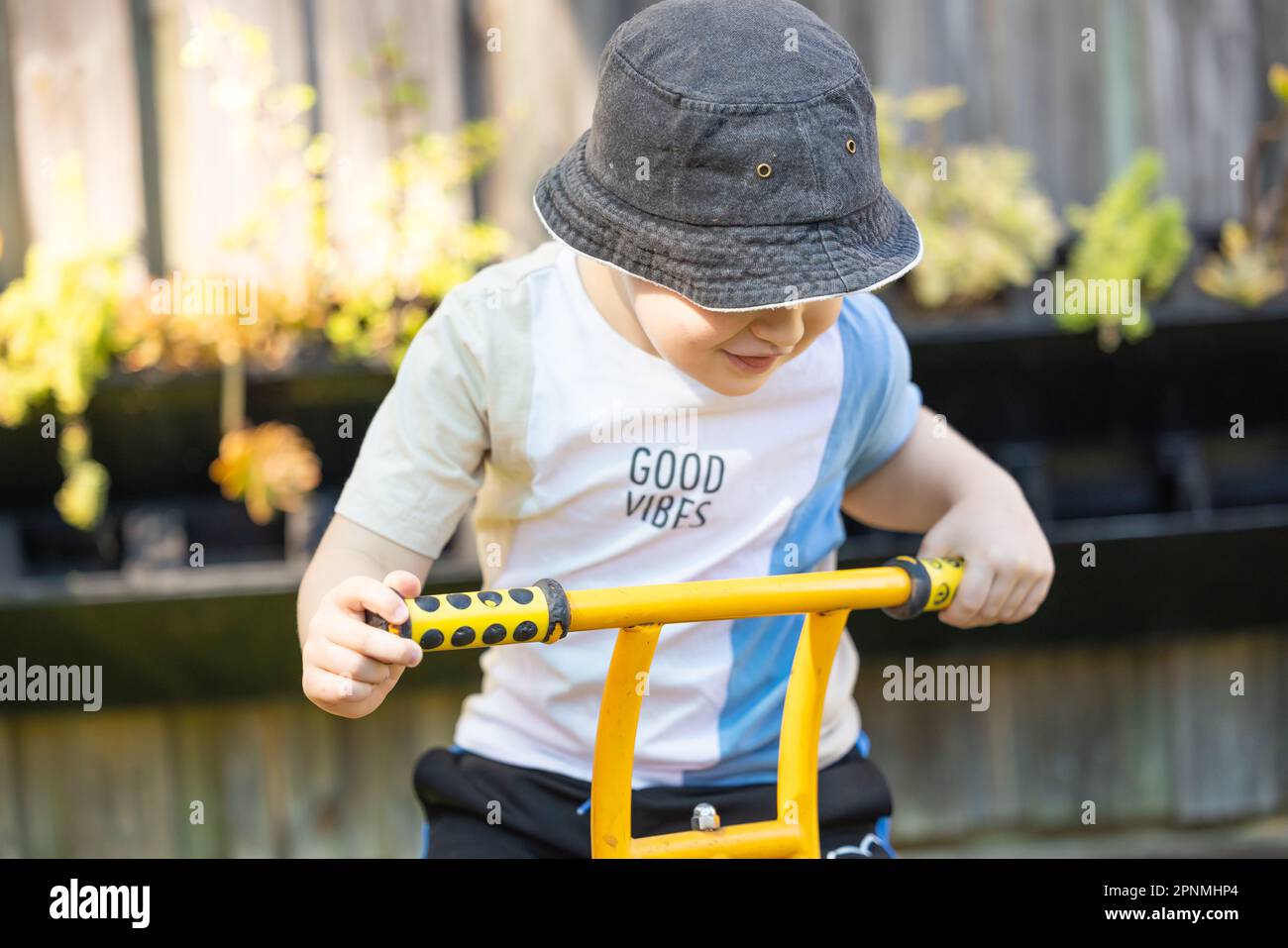 Enfant d'âge préscolaire à vélo dans une cour de jardin d'enfants en plein air animée et amusante Banque D'Images