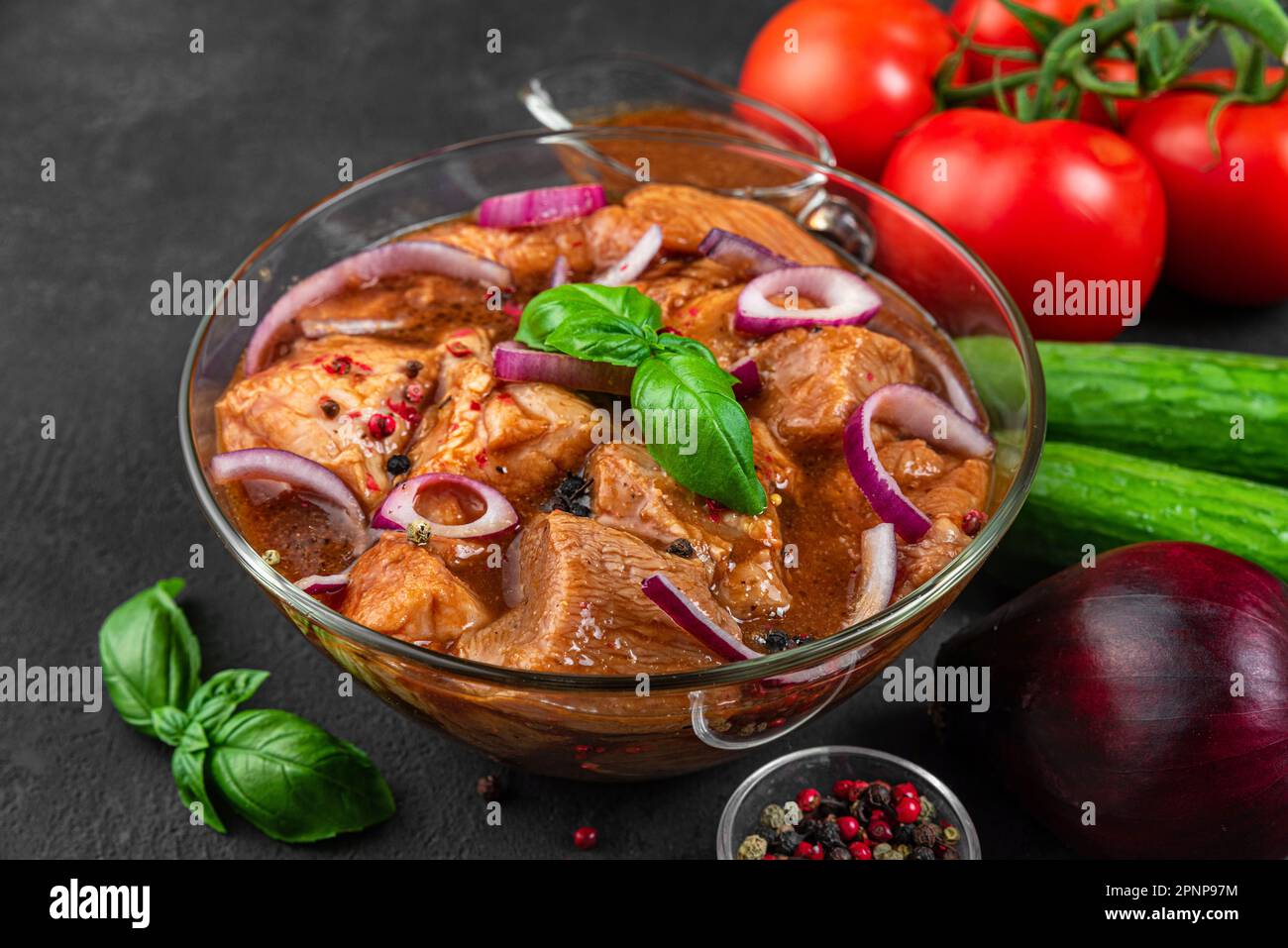 Kebab de porc cru mariné. Barbecue de viande avec des légumes sur fond noir. Cuisson de nourriture pour barbecue ou grill Banque D'Images